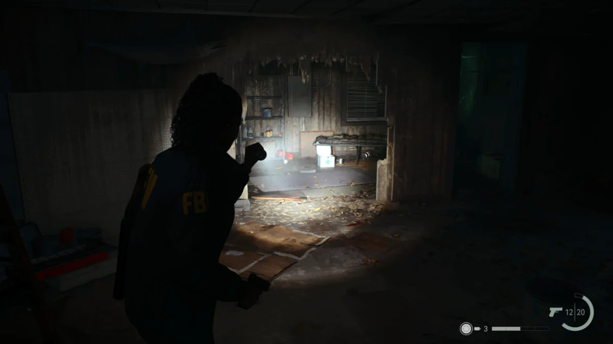 Saga leuchtet mit der Taschenlampe in Alan Wake 2 durch ein Loch in einer Wand eines Warenhauses.