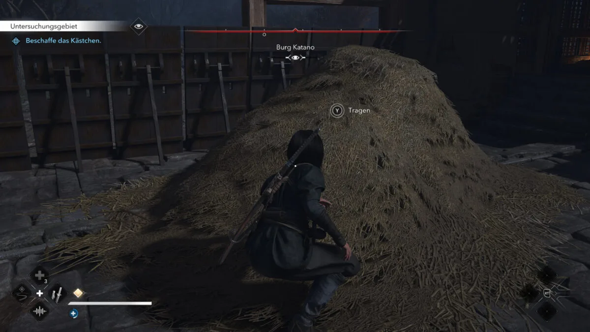 Shinobi Naoe hockt vor einem großen Heuhaufen.