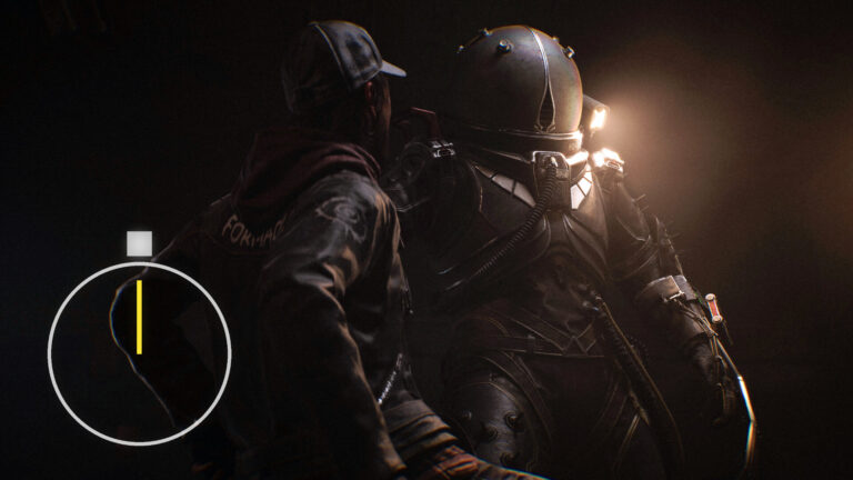 A man in combat gear grabs another man by the collar.