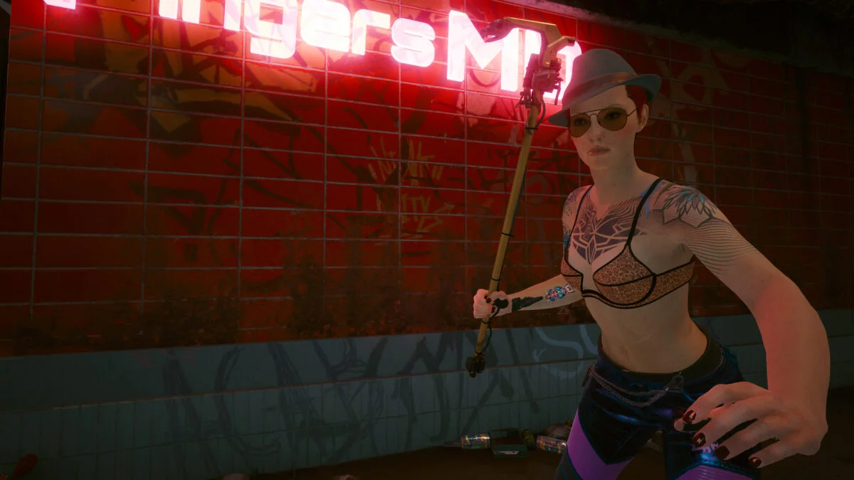 V mit der ikonischen Waffe Cottonmouth vor Fingers' Klinik in Cyberpunk 2077