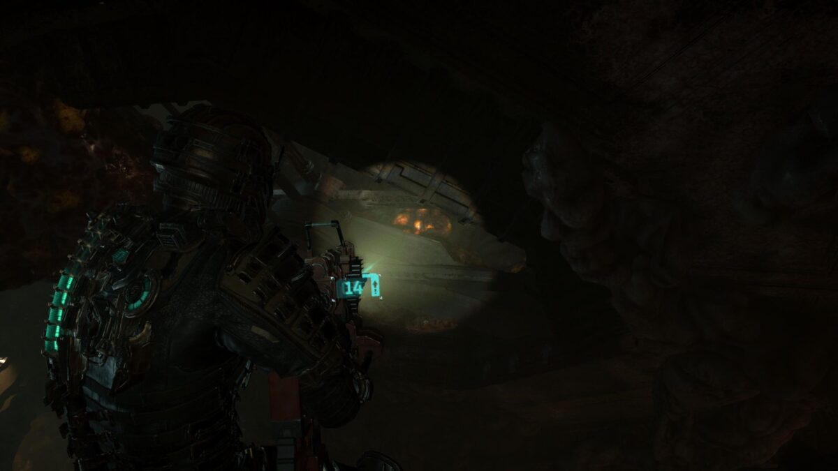 Isaac zielt in Dead Space auf ein leuchtendes Geschwulst an einer Ranke.
