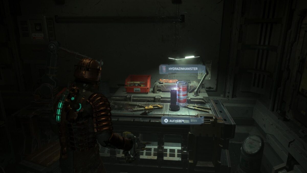 Isaac steht in Dead Space vor einer Werkbank, auf der ein Hydrazintank steht.