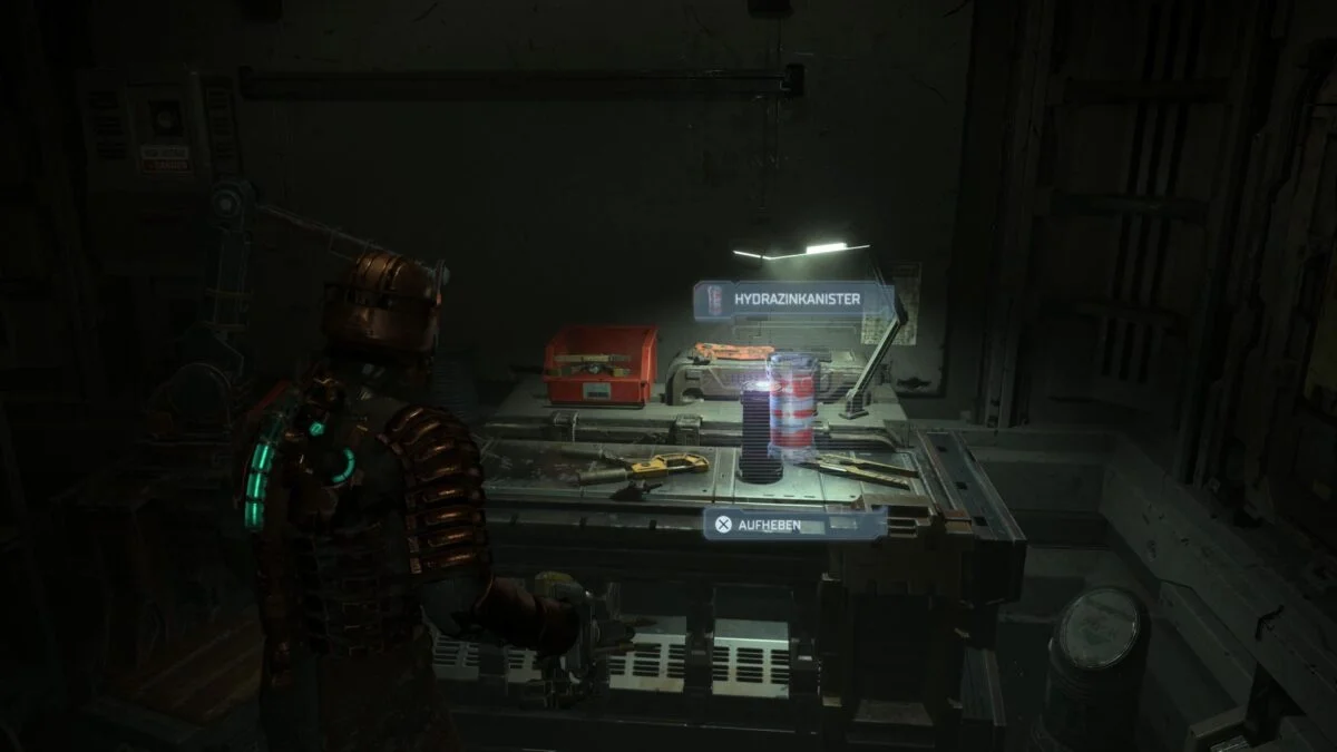 Isaac steht in Dead Space vor einer Werkbank, auf der ein Hydrazintank steht.