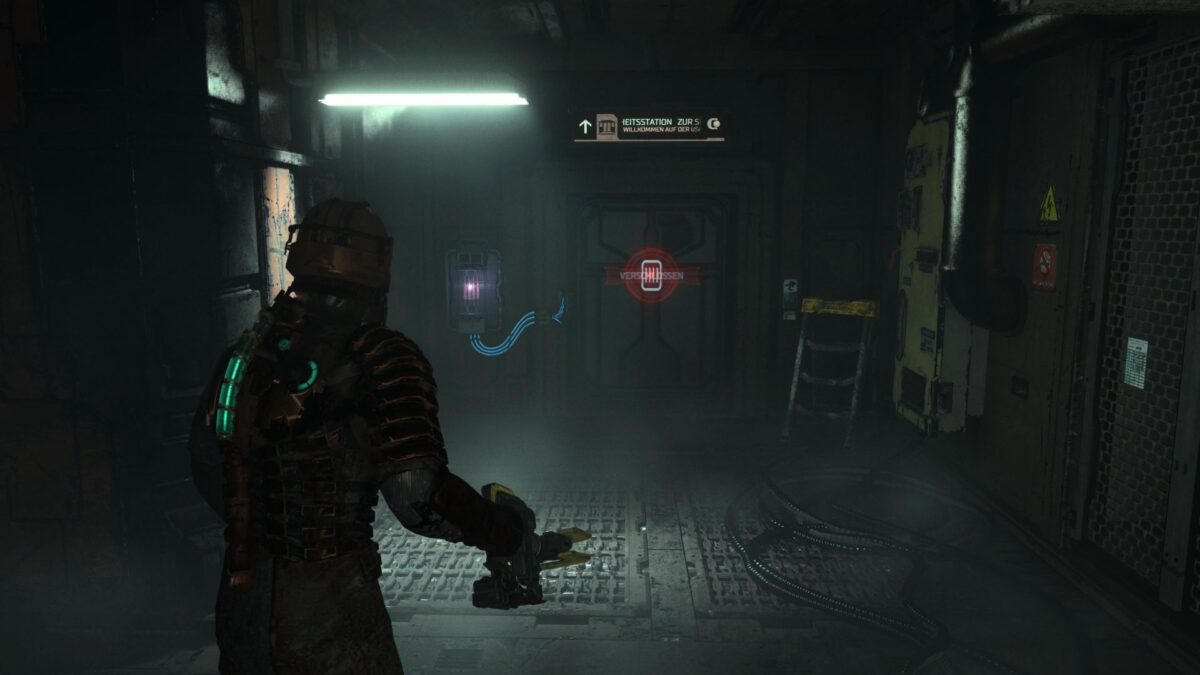 Isaac steht in Dead Space vor einer verschlossenen Tür, neben der eine leuchtende Schalttafel angebracht ist. 