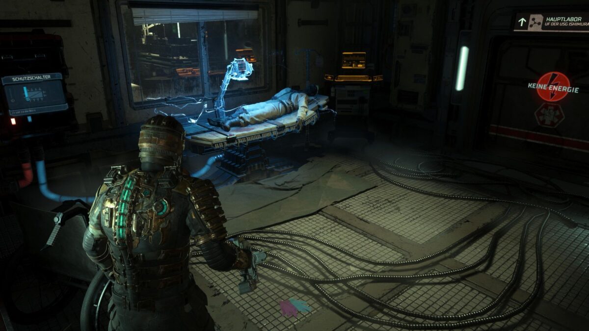 Isaac steht in Dead Space vor einer unter Strom stehenden Leiche, die auf einer Liege liegt.