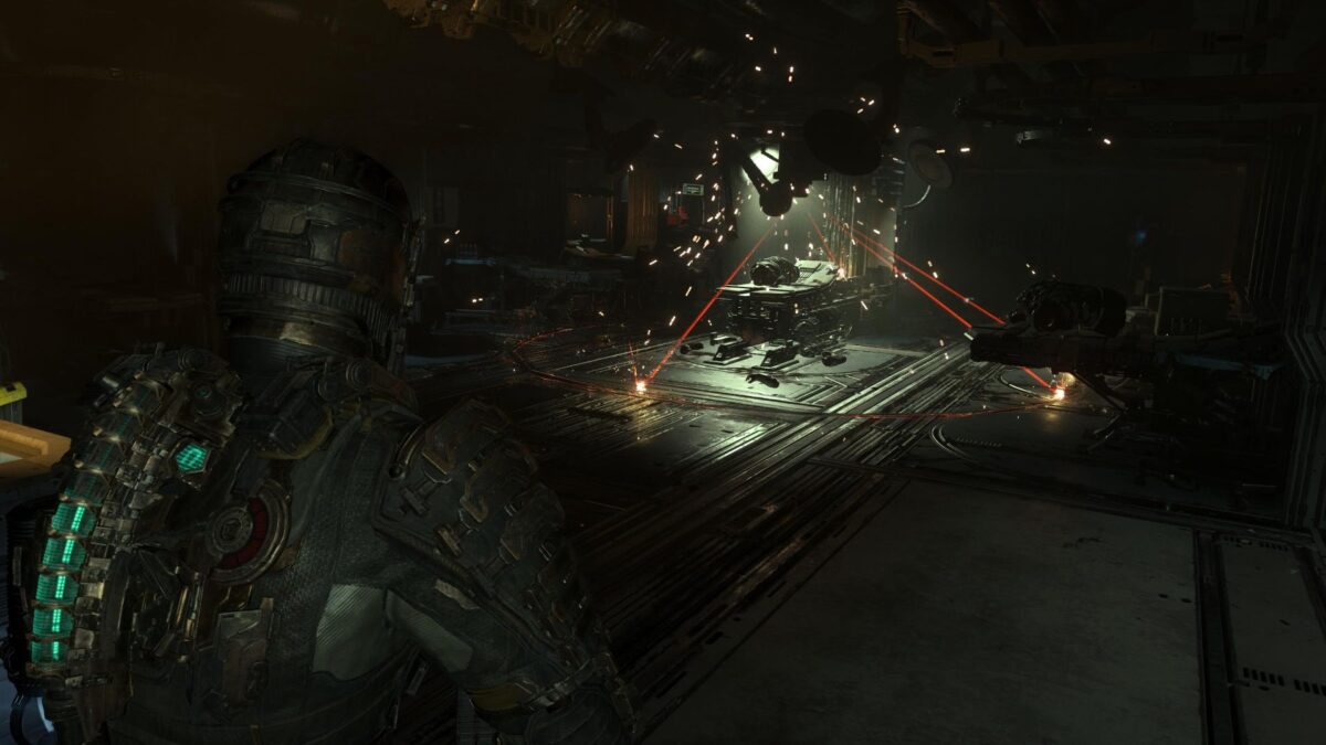 Isaac steht in Dead Space vor einem Laser mit mehreren roten Strahlen, die von der Decke herab leuchten.