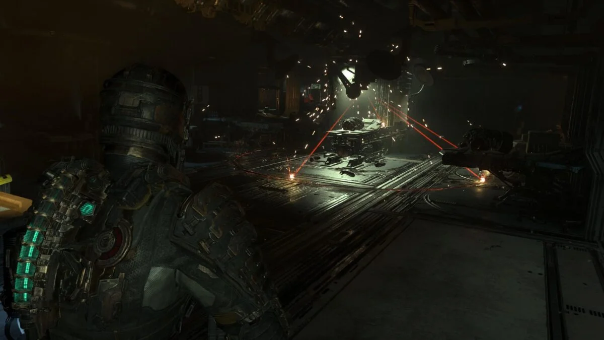 Isaac steht in Dead Space vor einem Laser mit mehreren roten Strahlen, die von der Decke herab leuchten.