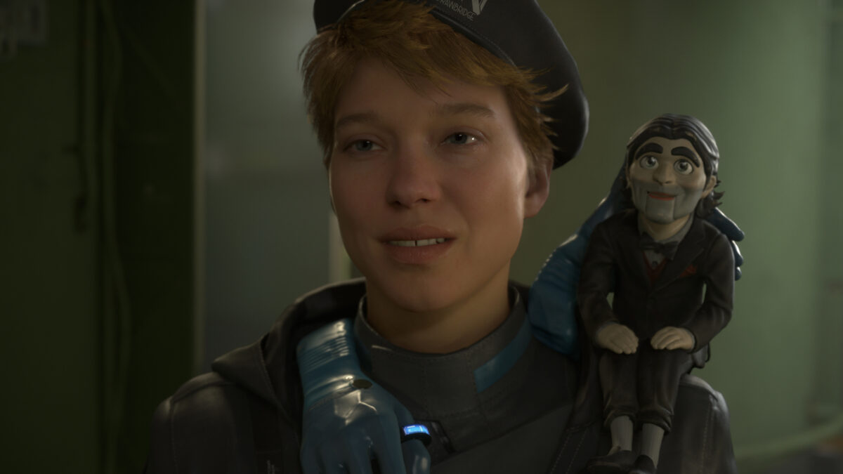 Eine Frau mit kurzen Haaren und Mütze hat eine kleine männliche Figur auf der Schulter.