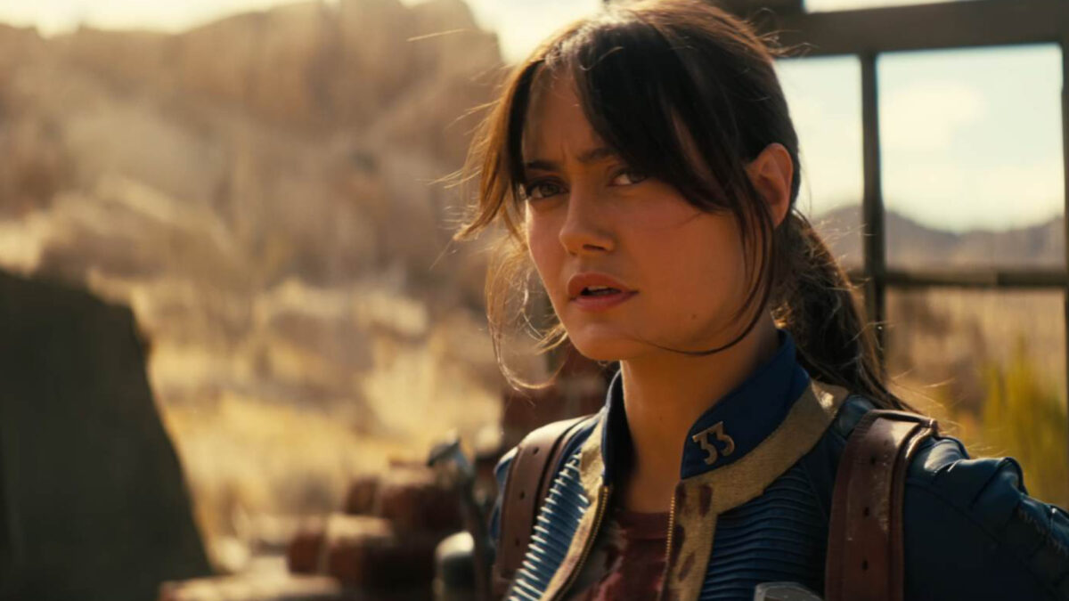 Eine Frau mit dunkelbraunen Haaren und blauem Anzug schaut konzentriert.