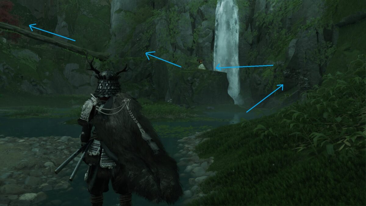 Atsu stands before two rocks connected by a fallen tree.
