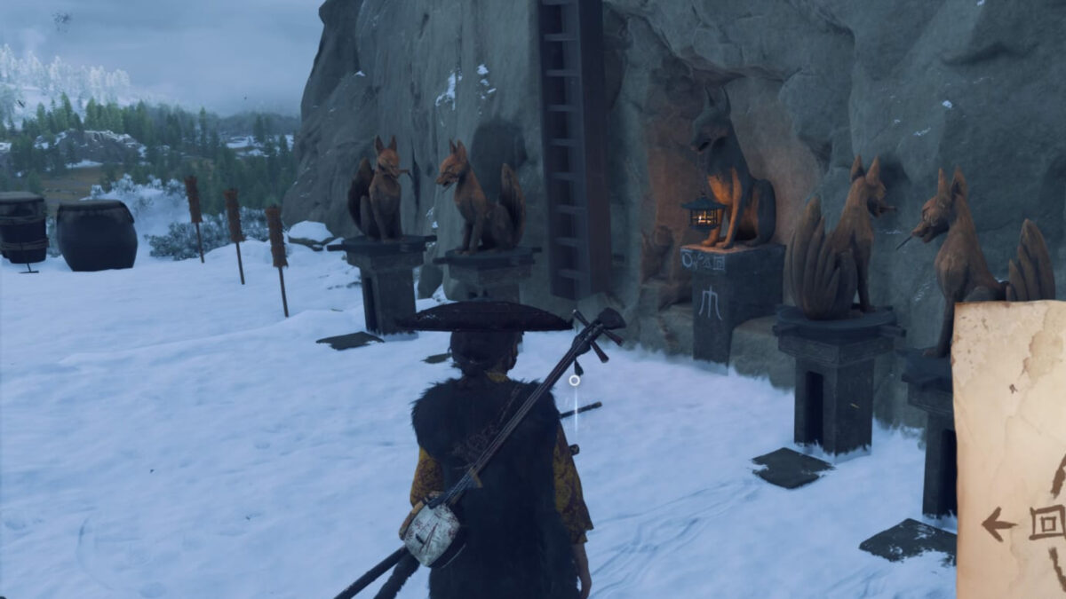 Atsu stands in front of four fox statues facing different directions.