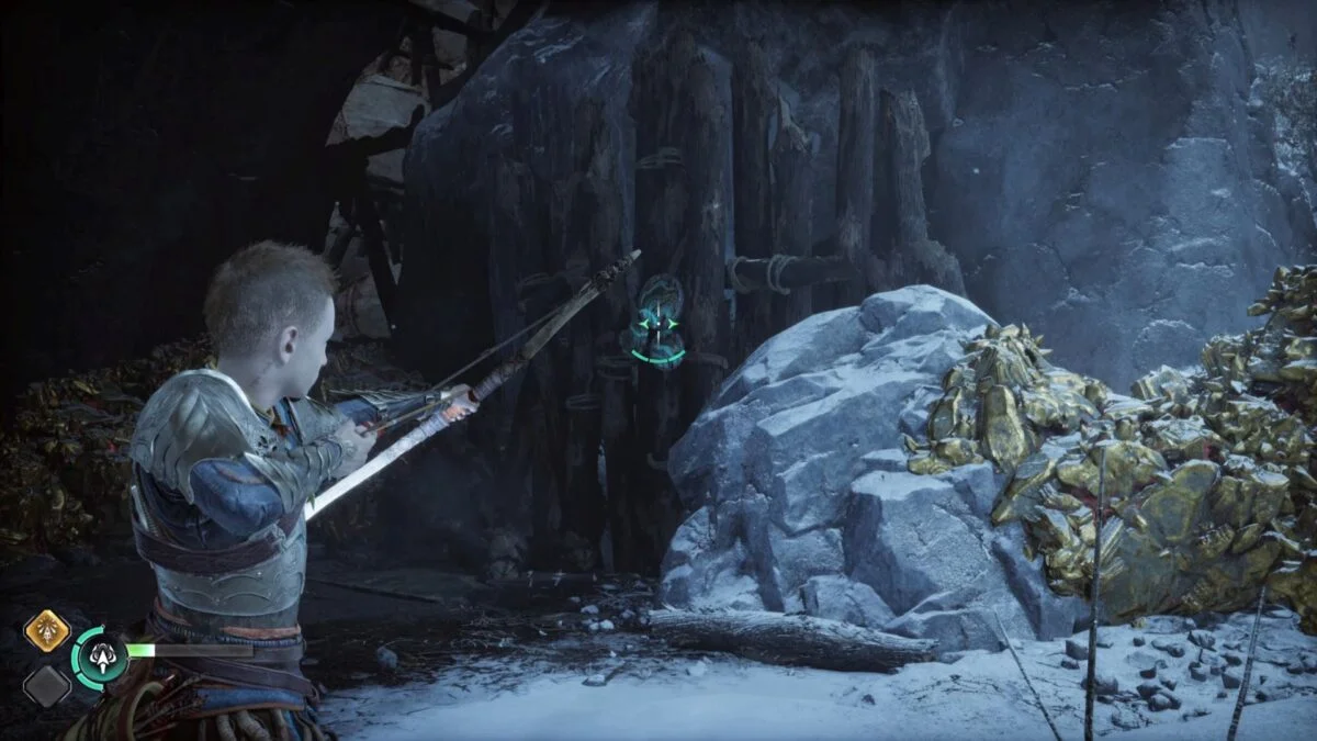 Atreus zielt mit dem Bogen in God of War Ragnarök auf einen grün schimmernden Stein an einer Holzwarnd.