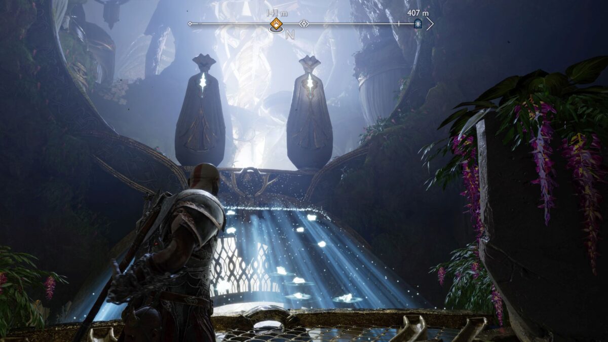 Kratos steht in God of War Ragnarök vor einer Licht-Brücke, die auf zweit Statuen zuführt. 