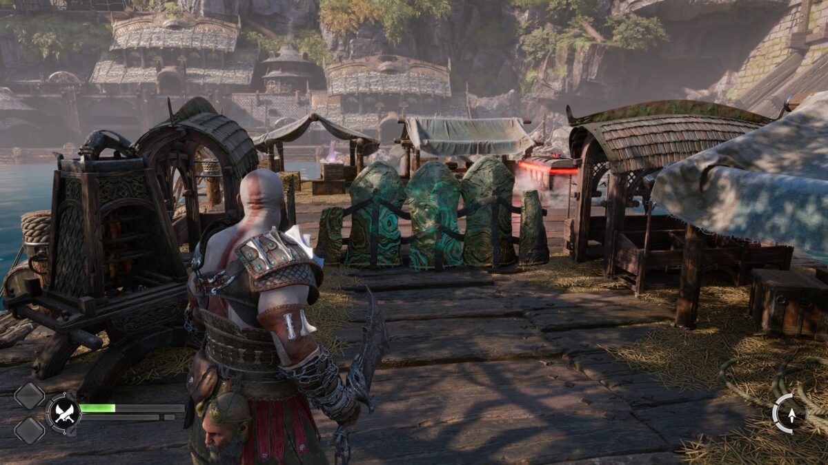 Kratos steht in God of War Ragnarök vor einer grün schimmernden Barrikade.