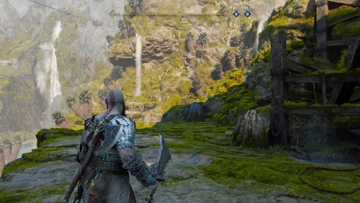Kratos steht in God of War Ragnarök vor einem blauen und einem bronzenen Felsen.