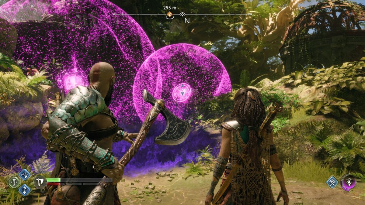 Kratos zielt mit der Axt auf zwei rosa leuchtende Kugeln in einem Dschungel. Neben ihm steht Freya. 