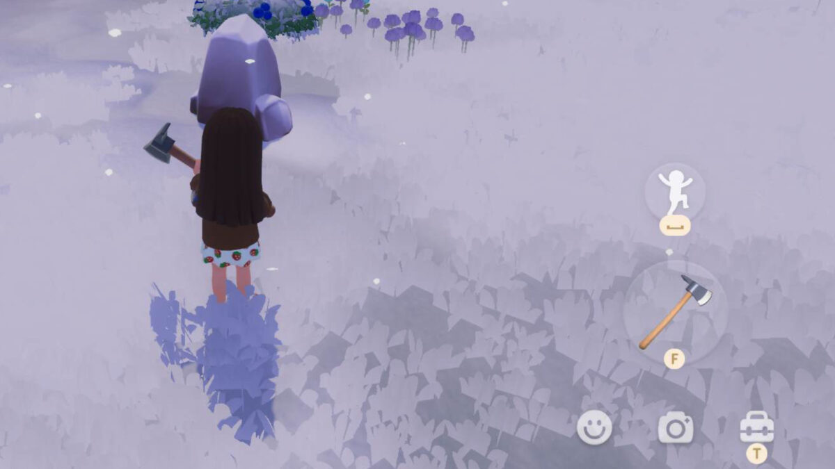 Ein Mädchen steht mit Axt vor einem Stein.