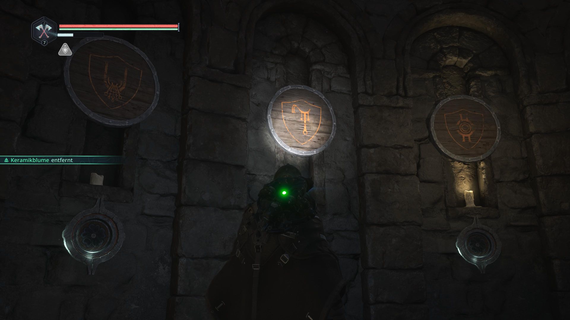 A man in a rain poncho stands before a wall with an emblem hanging on it.