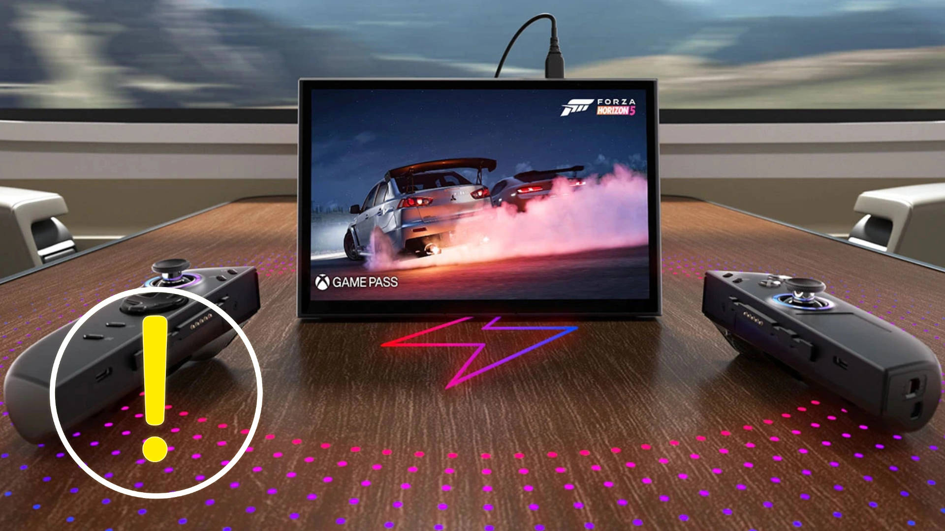 Ein Bildschirm steht auf einem Holztisch - davor zwei schwarze Controller.