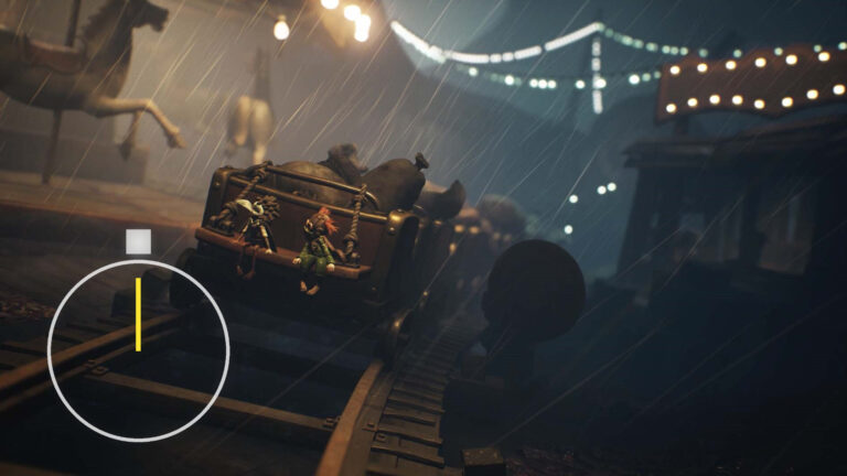 Two little figures are sitting on a wooden cart on rails.