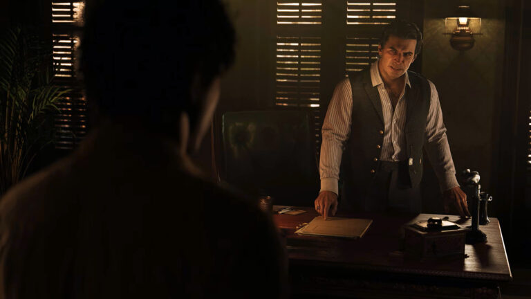 Two men face each other in a dark office. The man behind the desk has a serious facial expression.