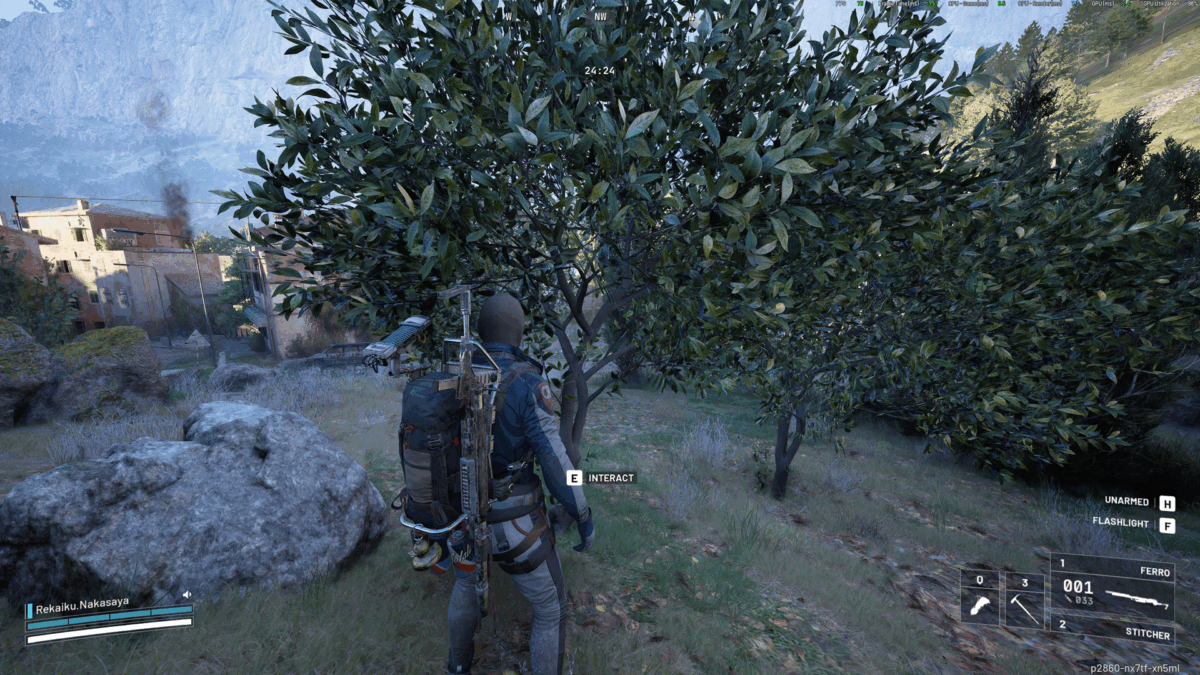 Ein Spieler steht mit ausgerüsteter Waffe und Rucksack vor einem Olivenbaum in einer hügeligen Landschaft; im Hintergrund sind Gebäude und aufsteigender Rauch zu sehen – Spielszene aus ARC Raiders.