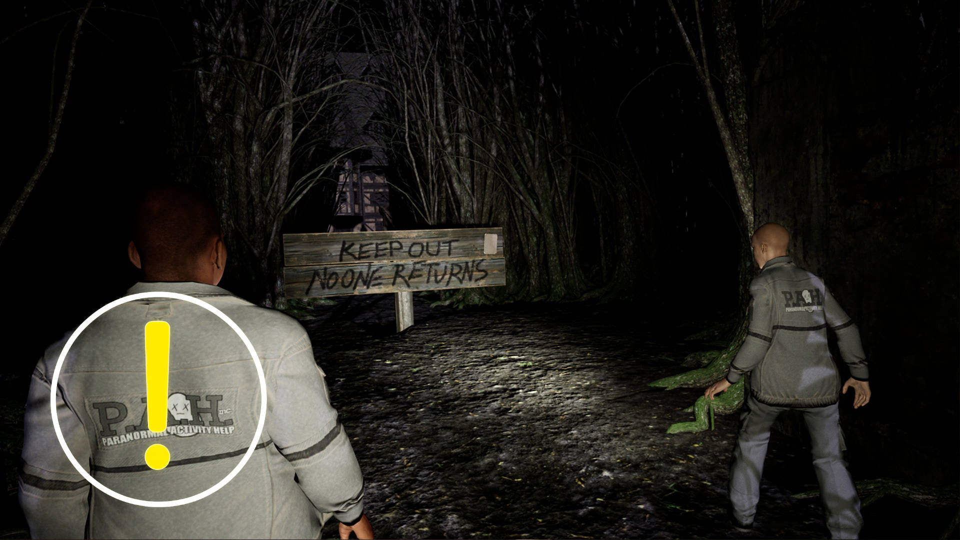 Two people are standing in the dark in front of a wooden sign.