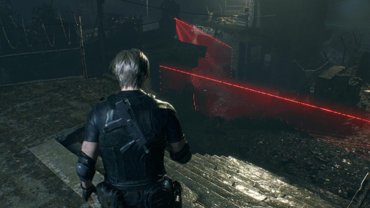 Leon steht in Resident Evil 4 Remake auf einer Treppe und blickt auf rot leuchtende Laserschranken.