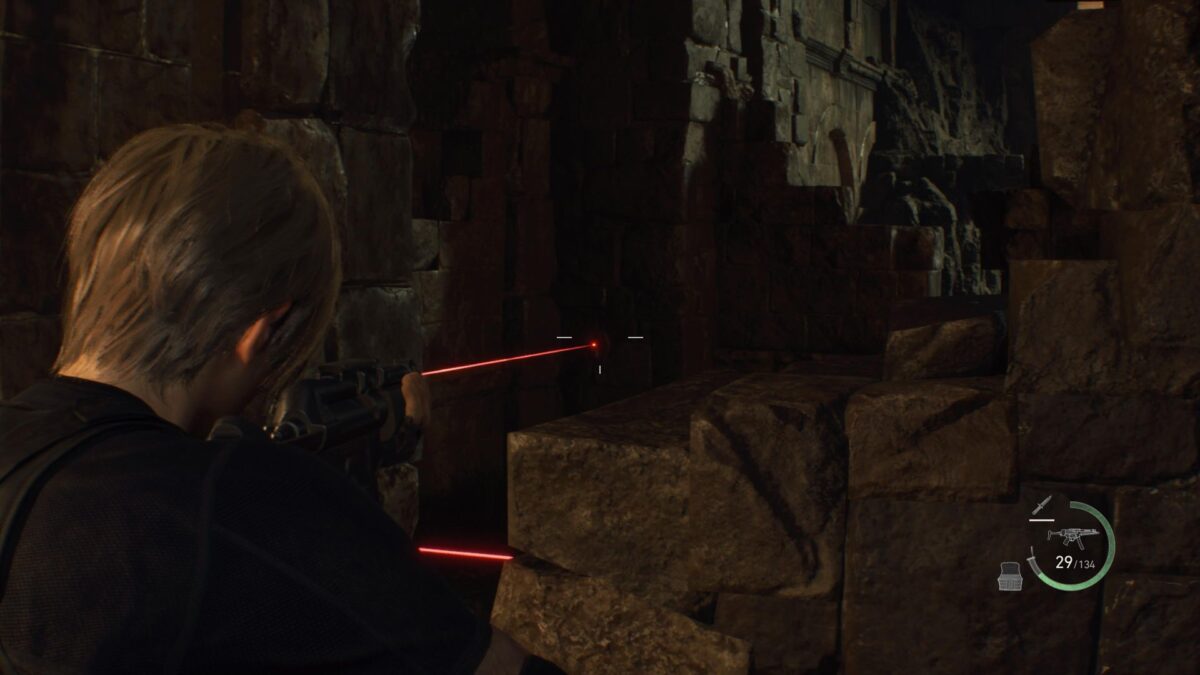 Leon zielt mit der Pistole auf den Sensor einer Laserschranke.