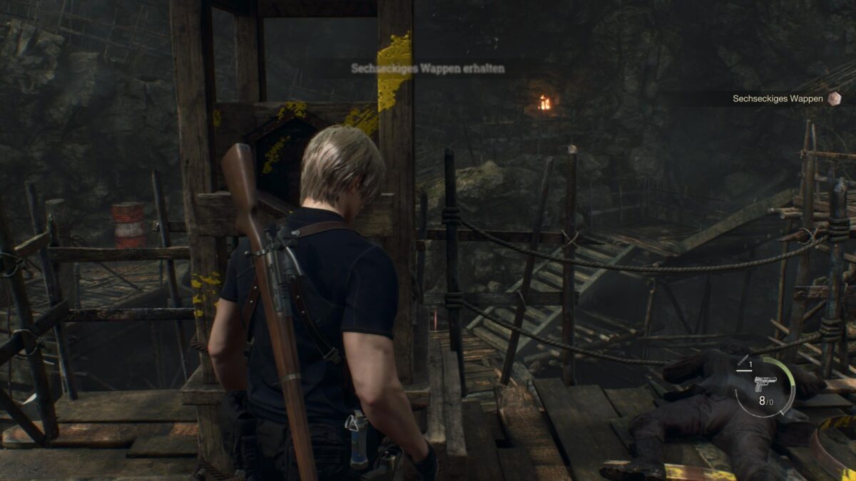 Leon steht in Resident Evil 4 vor einem Türmchen, an dem das sechseckige Wappen hängt. 