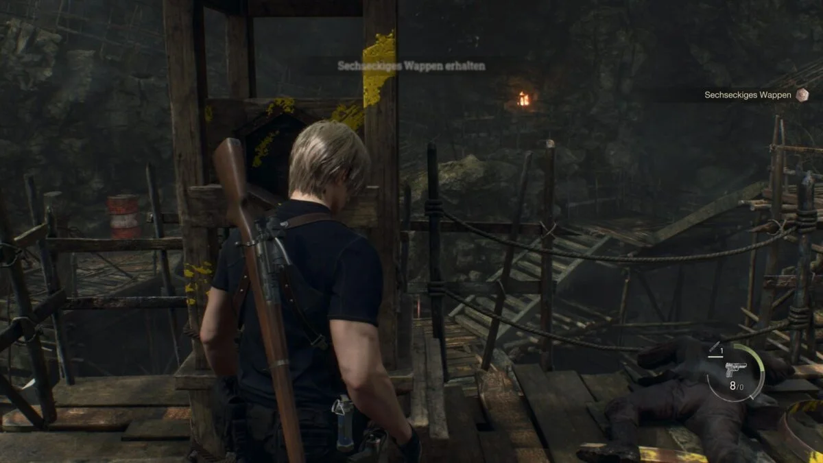 Leon steht in Resident Evil 4 vor einem Türmchen, an dem das sechseckige Wappen hängt. 