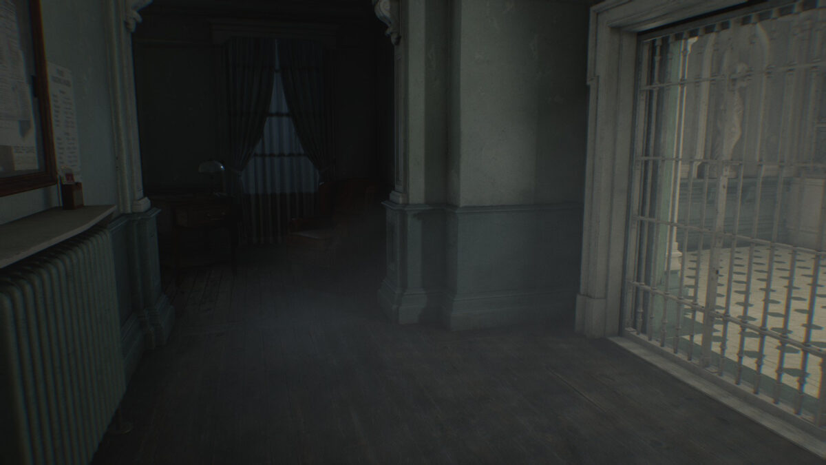 Ein Tor, daneben ein Sessel und ein Tisch in einem dunklen Flur.