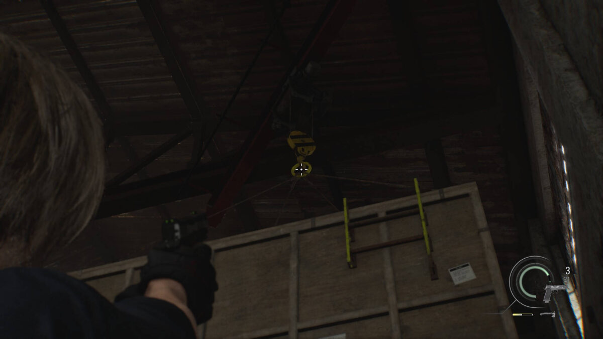 Leon zielt mit einer Waffe auf eine Kiste.