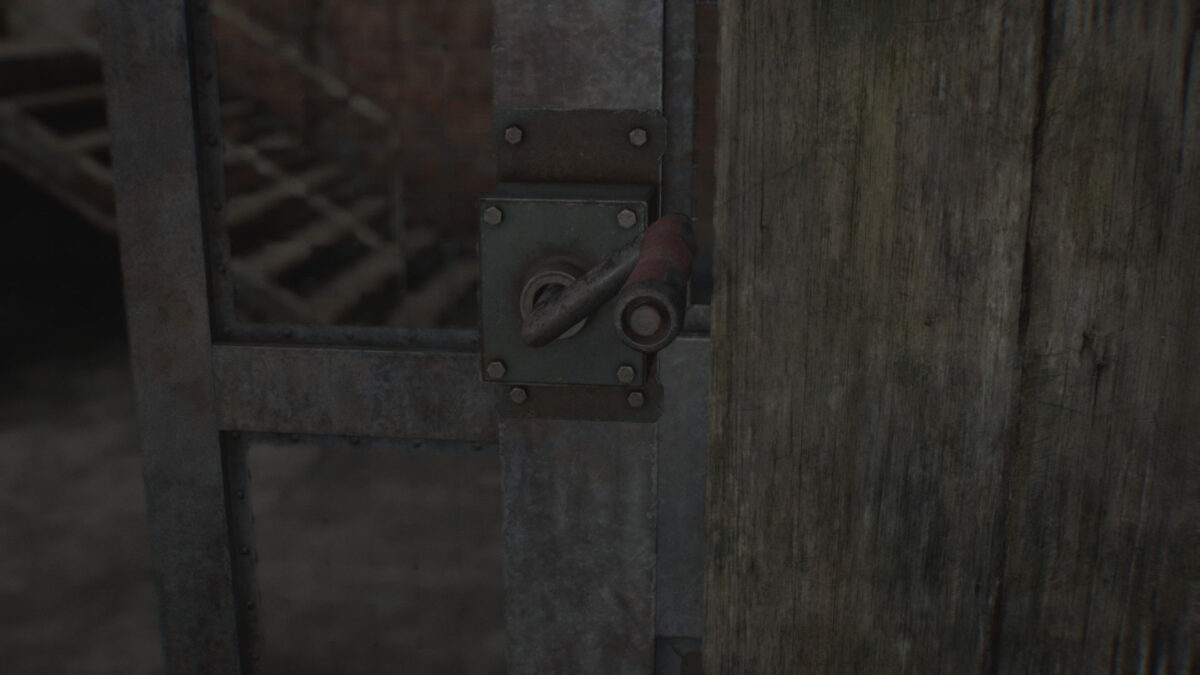 Eine Kurbel an einer Gittertür.