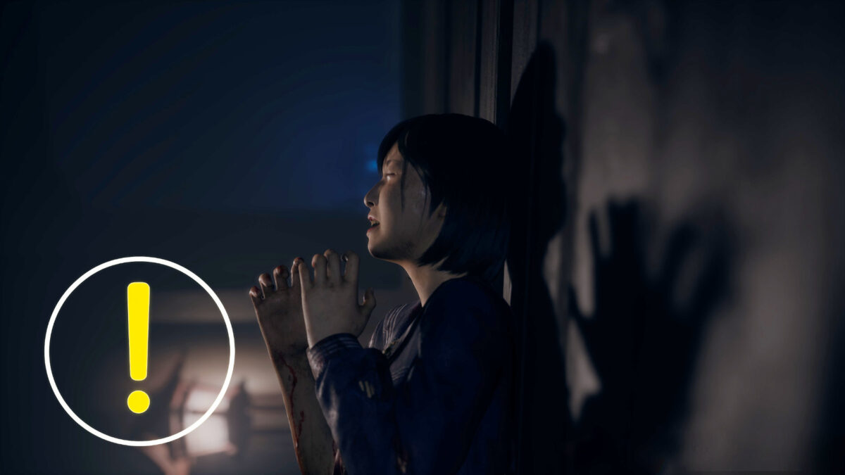 A schoolgirl leans against a wall, crying in despair.