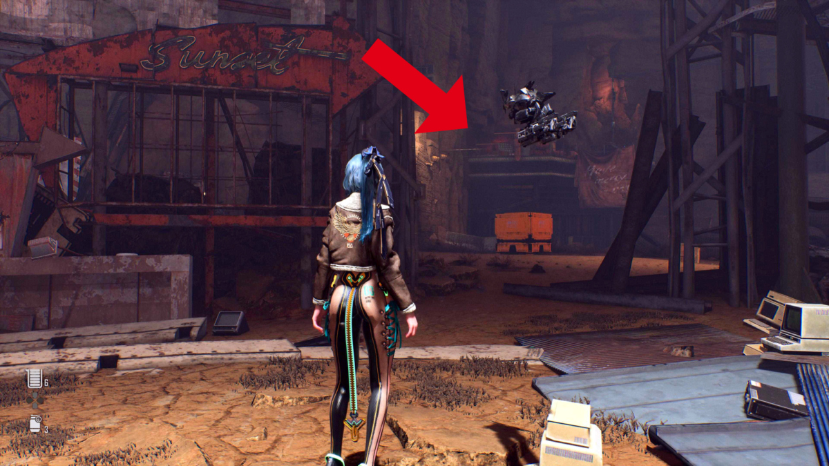 Protagonistin Eve steht in Stellar Blade auf einem Schrottplatz. Ein roter Pfeil zeigt auf eine Plattform. 