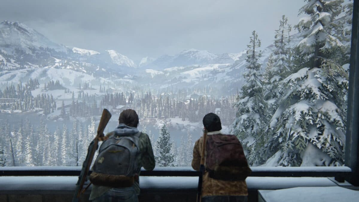 Zwei Frauen lehnen an einer Brüstung und genießen die Aussicht auf eine verschneite Gebirgslandschaft in dem Spiel The Last of Us Part II.