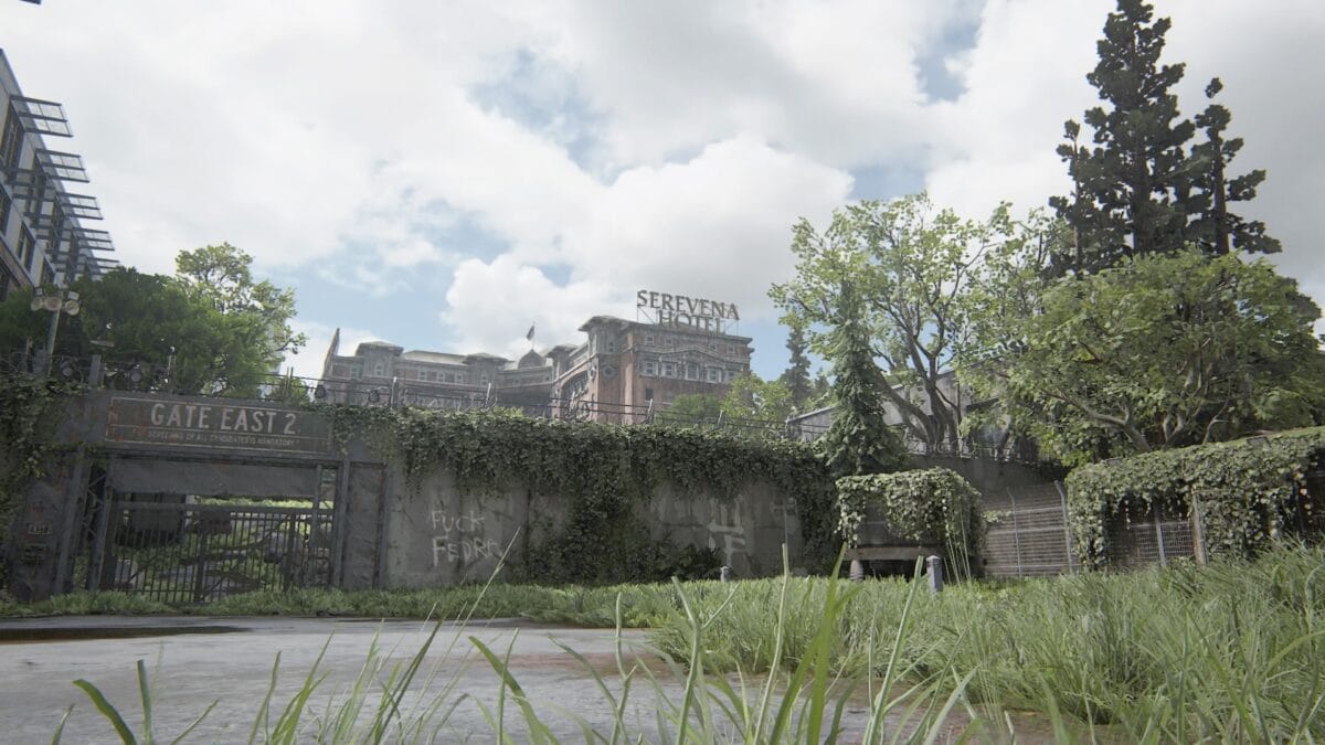 Das Tor einer Absperrung mit der Aufschrift "Fuck Fedra" verhindert den Zugang zum Serevena Hotel in The Last of Us Part 2.