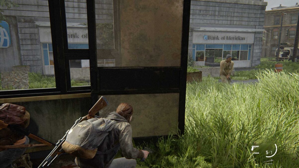 Ellie und Dina verstecken sich im Inneren eines leeren Geschäfts vor den WLF-Soldaten in The Last of Us Part 2.