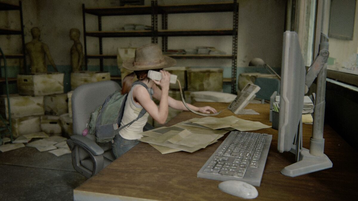 Ellie sitzt in The Last of Us Part 2 an einem Schreibtisch und spielt Sekretärin.