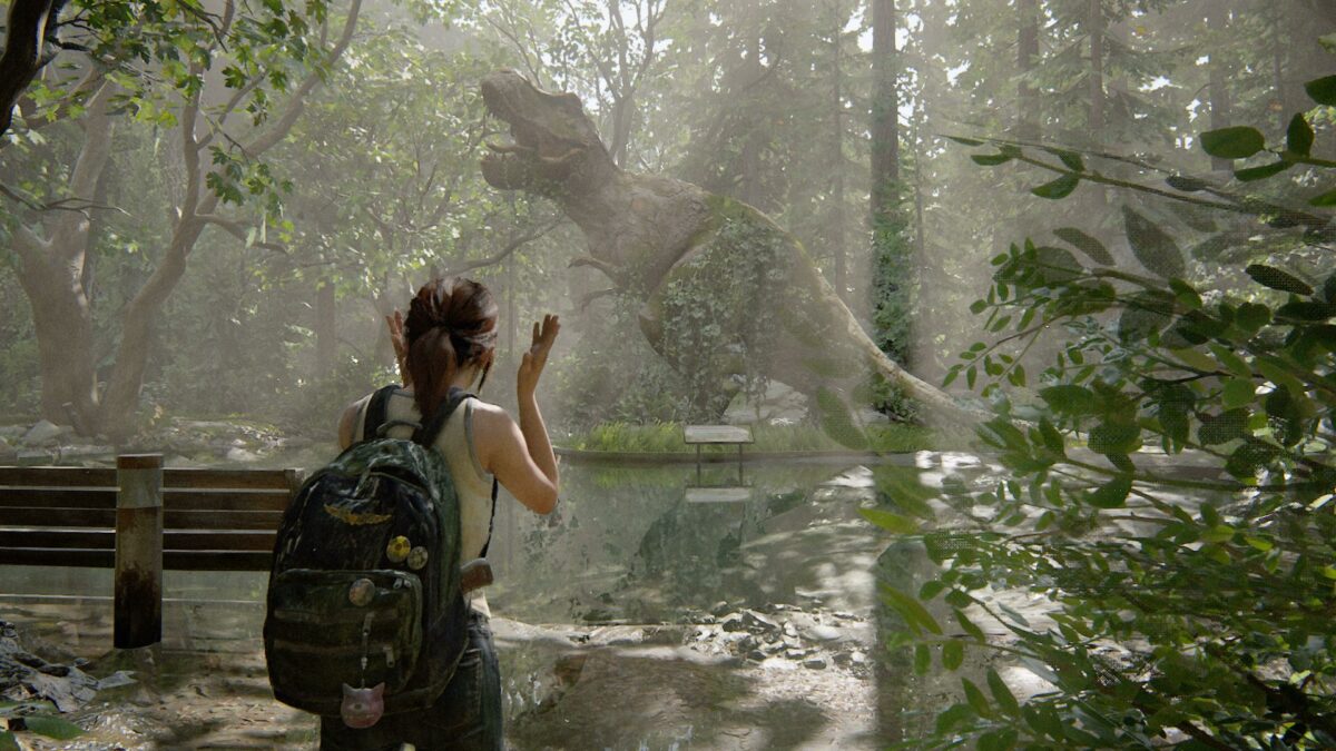 Die junge Ellie steht in The Last of Us Part 2 vor einer riesigen T-Rex-Statue.