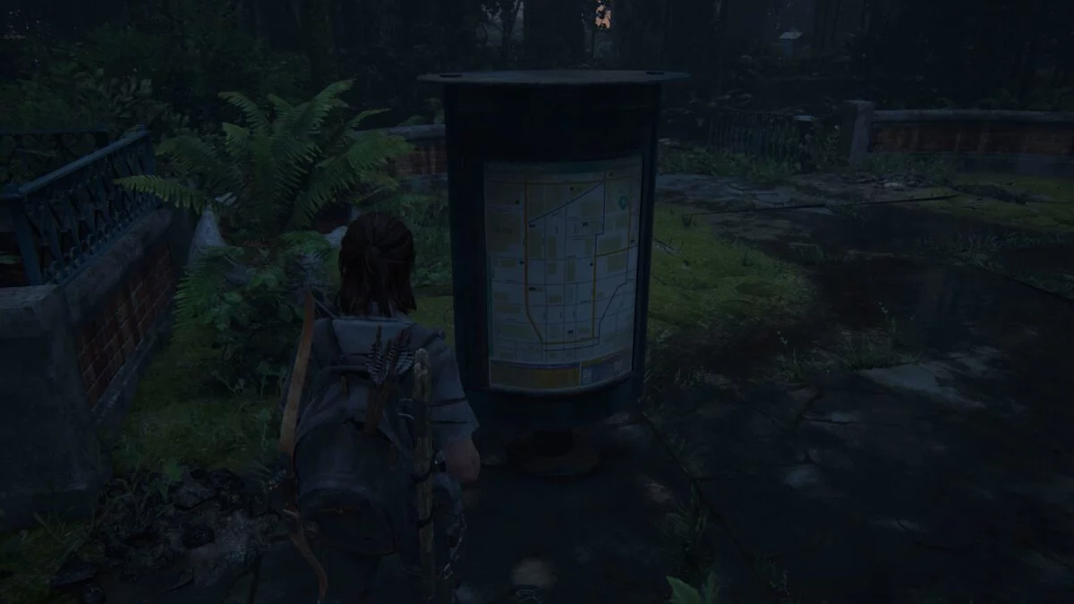 Ellie sieht sich eine Karte des vor ihr liegenden Gebiets in The Last of Us Part 2 an.