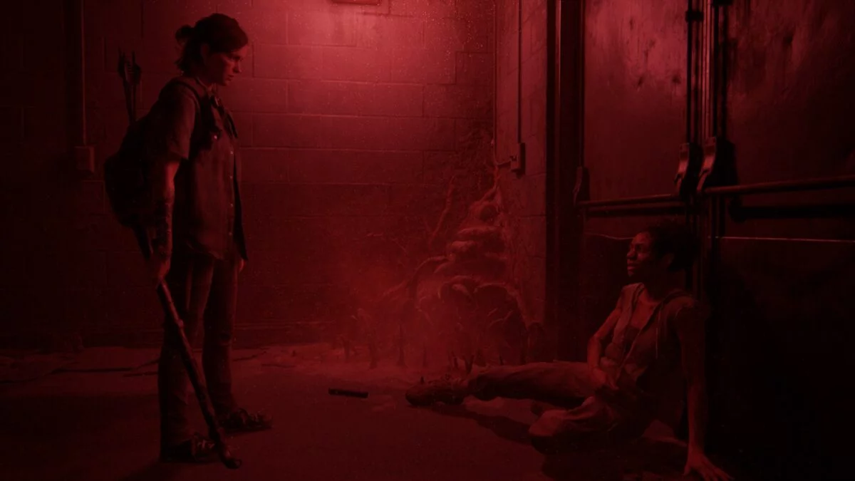 Ellie und Nora stehen sich im roten Schein des Kellerlichts in The Last of Us Part 2 gegenüber.
