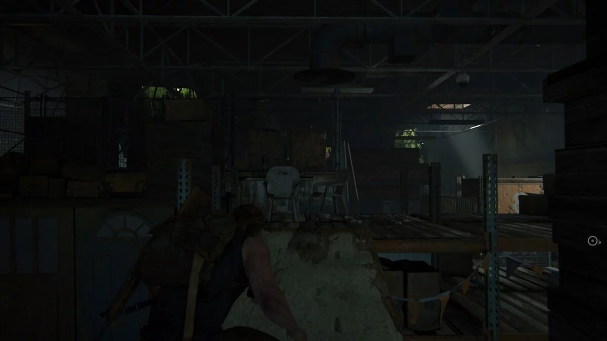 Abby klettert in The Last of Us 2 über eine Planke zwischen den Lagerregalen umher. 