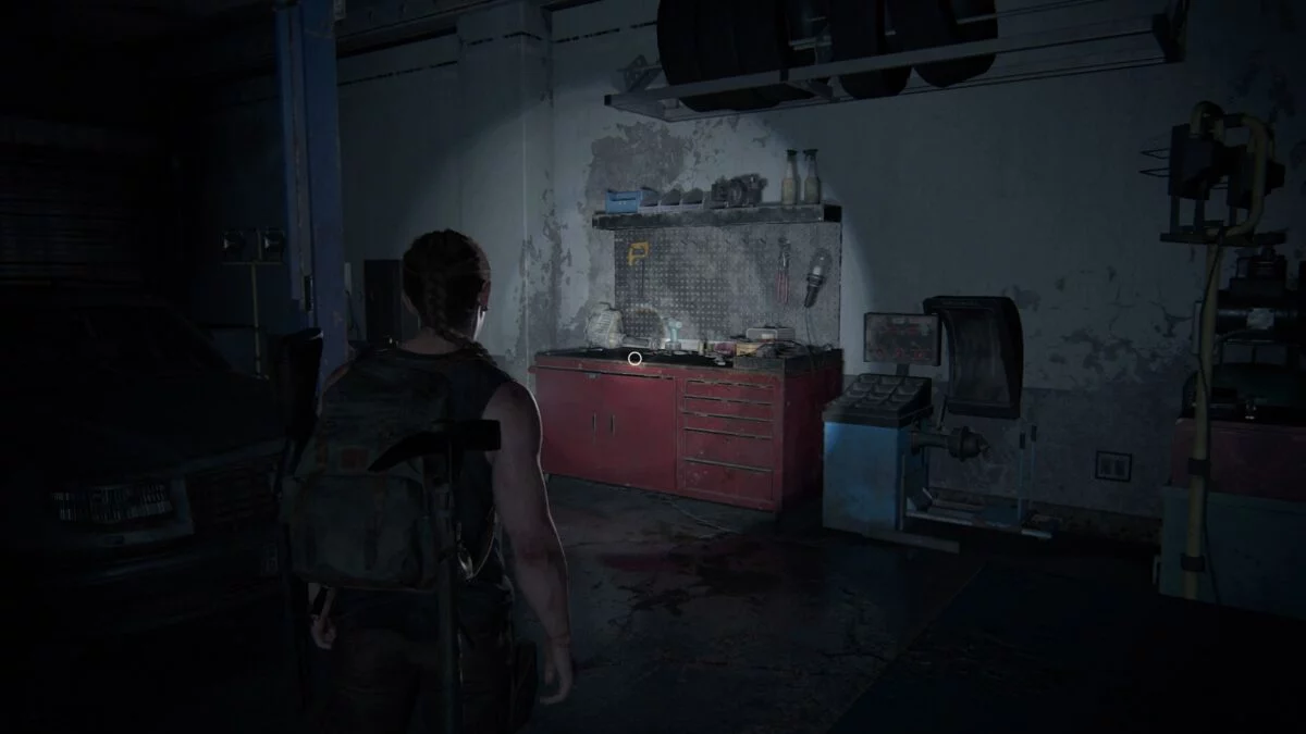 Abby findet in The Last of Us 2 eine Werkbank in einer Autowerkstatt.