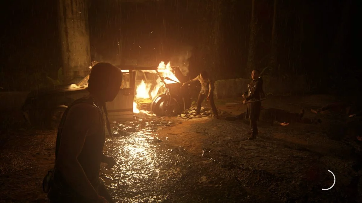 Abby, Lev und Yara stehen in The Last of Us 2 im Wald an einem brennenden Autowrack.