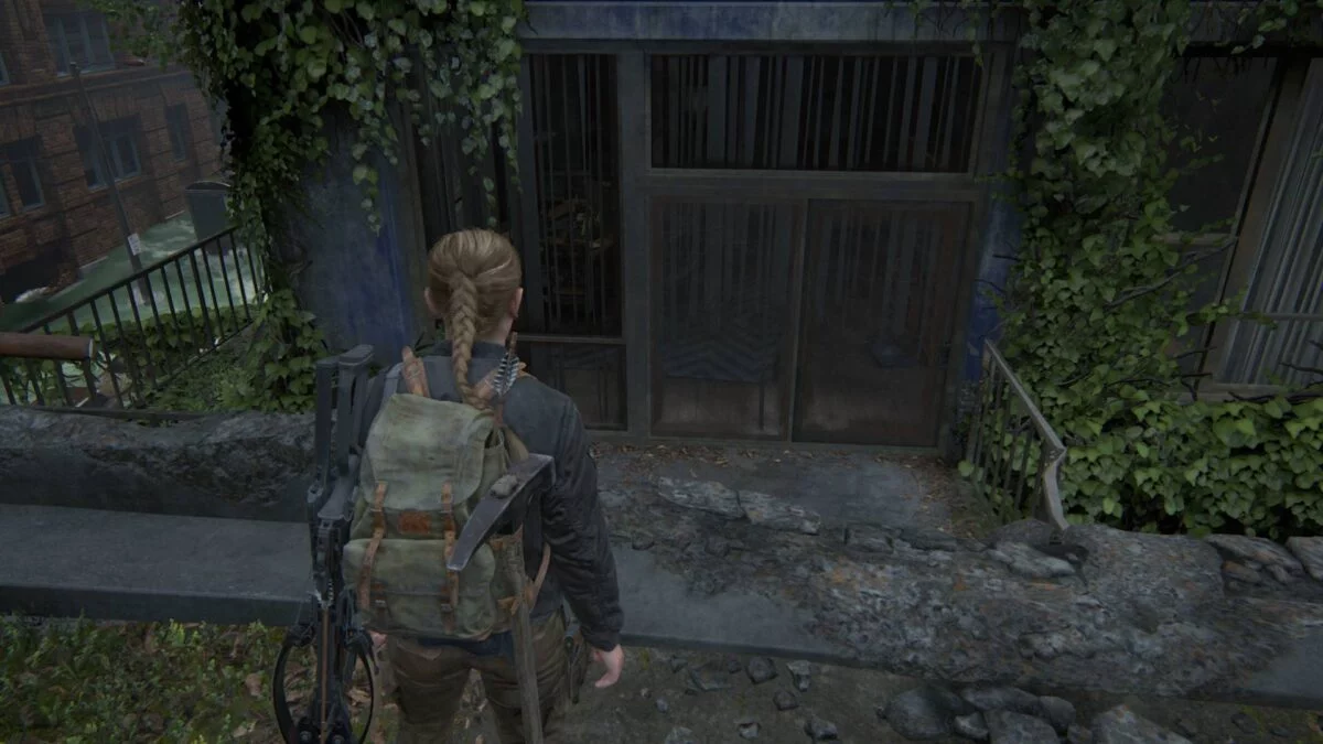 Abby steht in The Last of Us 2 am Rand einer Brücke und blickt auf einen Balkon.