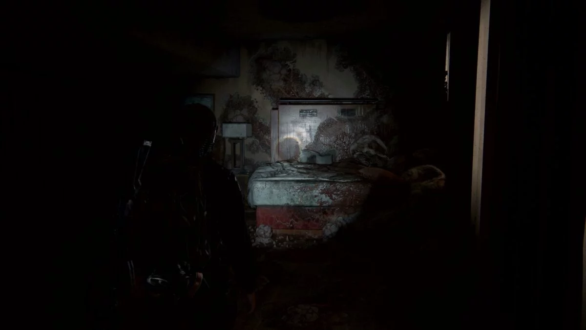 Abby blickt in The Last of Us 2 auf ein von Pilzen umwuchtertes Hotelzimmerbett. 