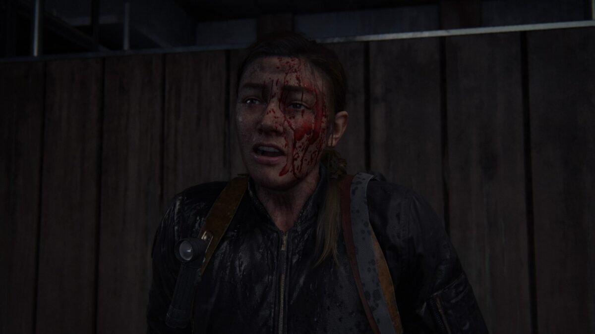 Abby sitzt in The Last of Us 2 mit blutverschmiertem Gesicht am Boden.