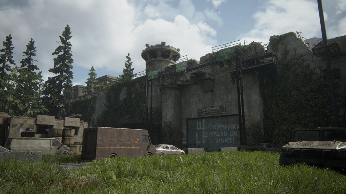 Giant, locked gate with some car wreckages in front of it in The Last of Us 2.